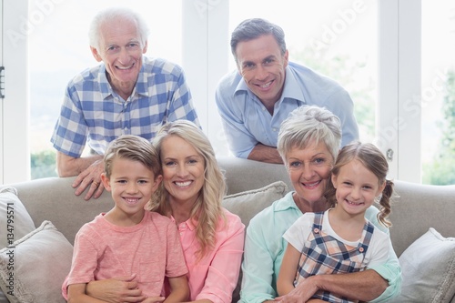 Multi generation family sitting on sofa in living room