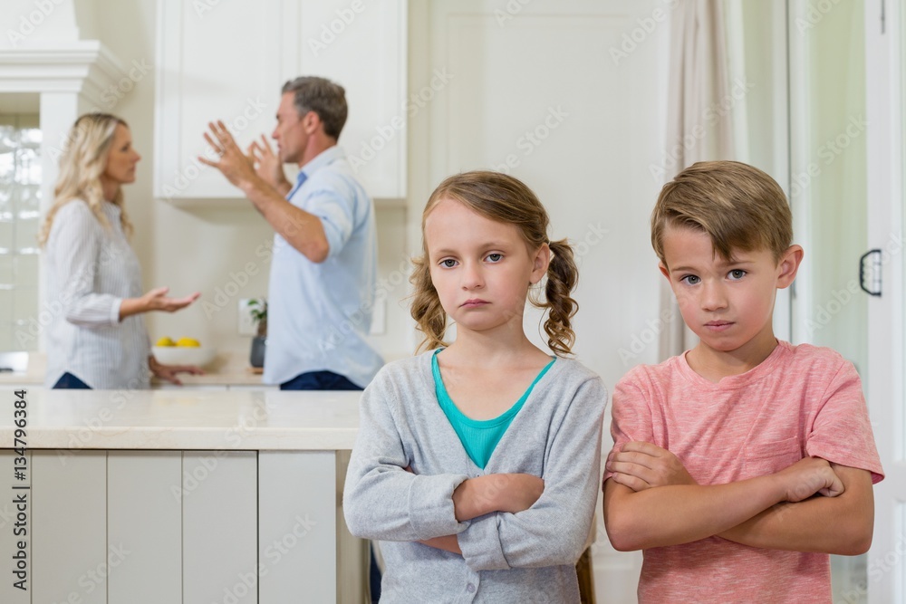 Sad sibling standing with arms crossed