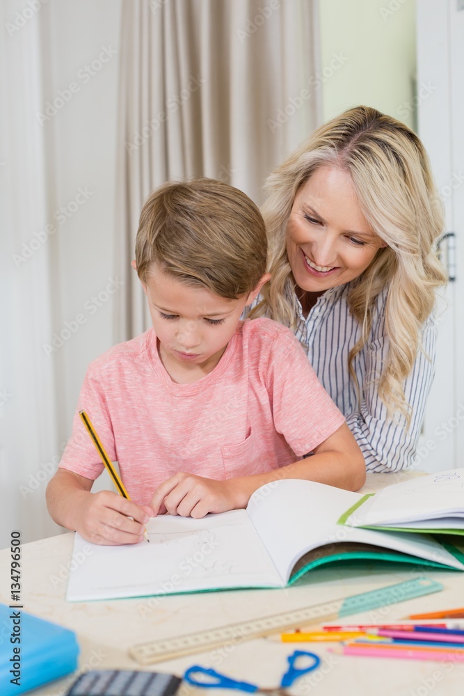 Mother assisting son doing homework Mother assisting son doing homework