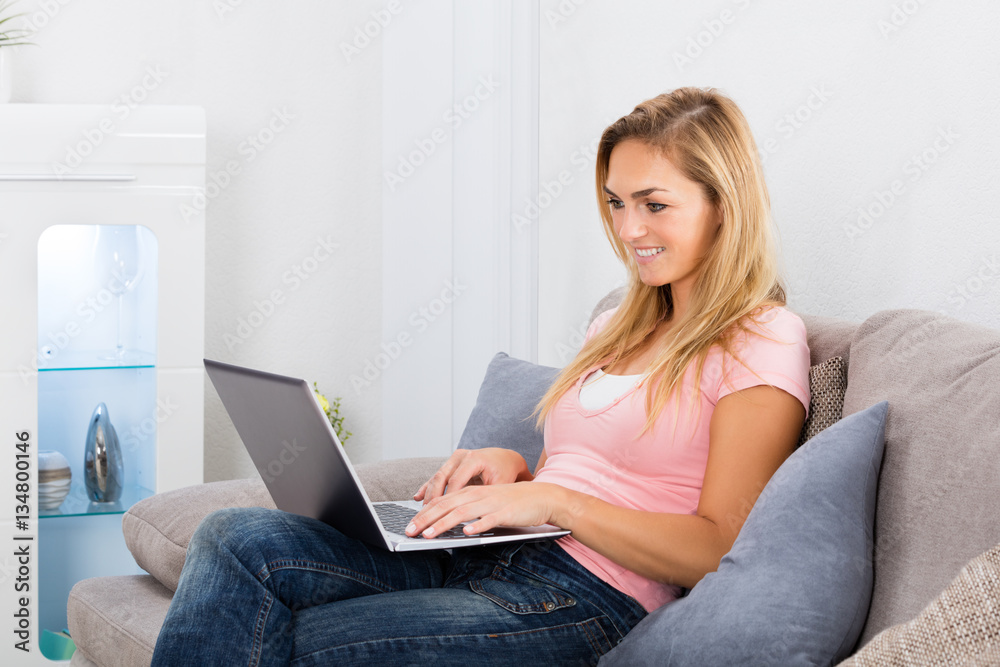 Smiling Woman Using Laptop At Home Smiling Woman Using Laptop At Home