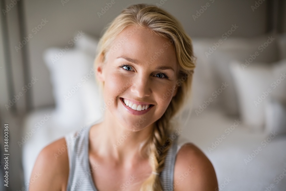 Smiling beautiful woman sitting on bed in bedroom Smiling beautiful woman sitting on bed in bedroom