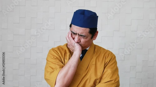 疲れた表情の寿司職人
