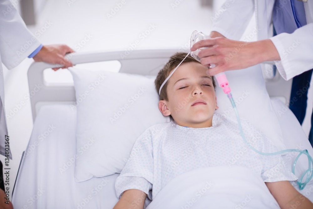 Doctor putting an oxygen mask on patient Doctor putting an oxygen mask on patient