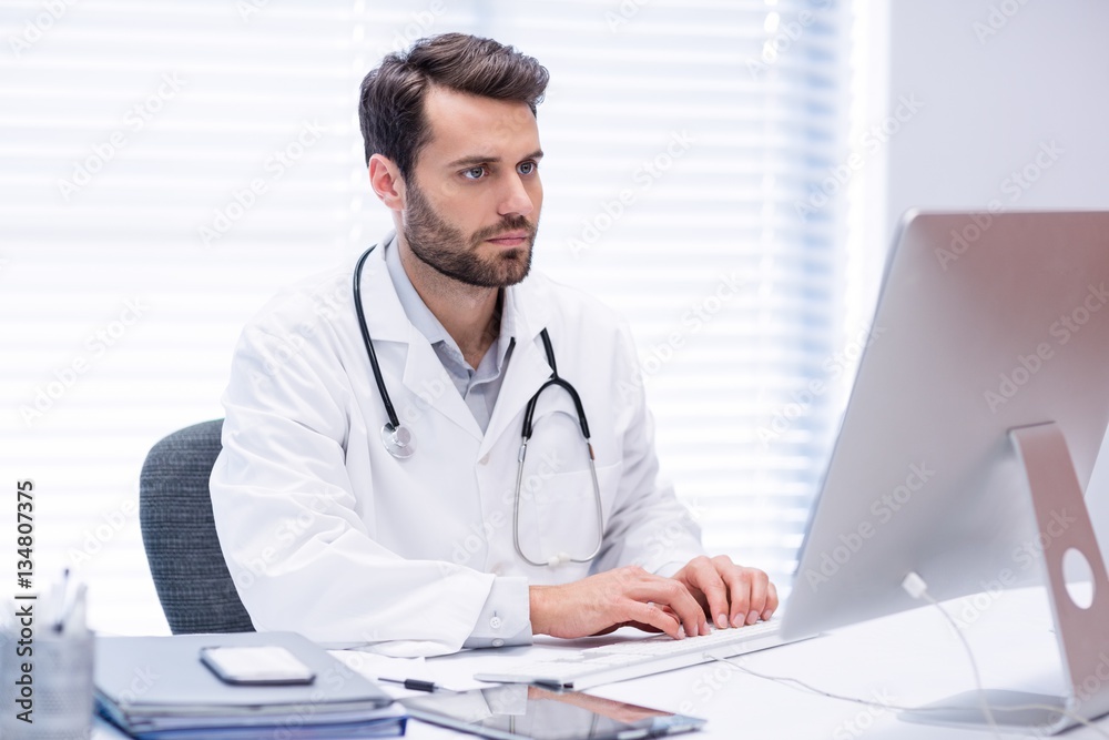 Male doctor working on personal computer Male doctor working on personal computer