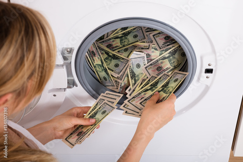 Person Inserting Money In Washing Machine