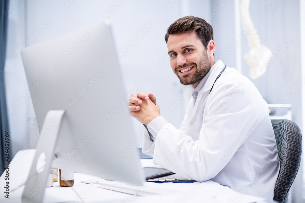 Portrait of male doctor sitting at desk Portrait of male doctor sitting at desk