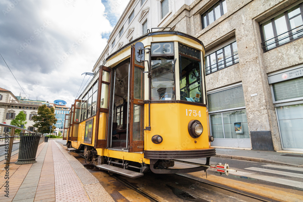 Vintage orange tram on the street of Milano near city center, Lombardia region, Italy.