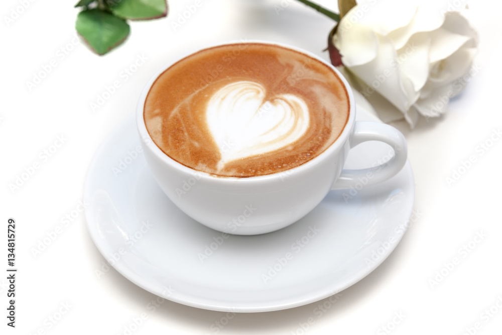 Coffee cup of heart shape latte art on the plate with white rose