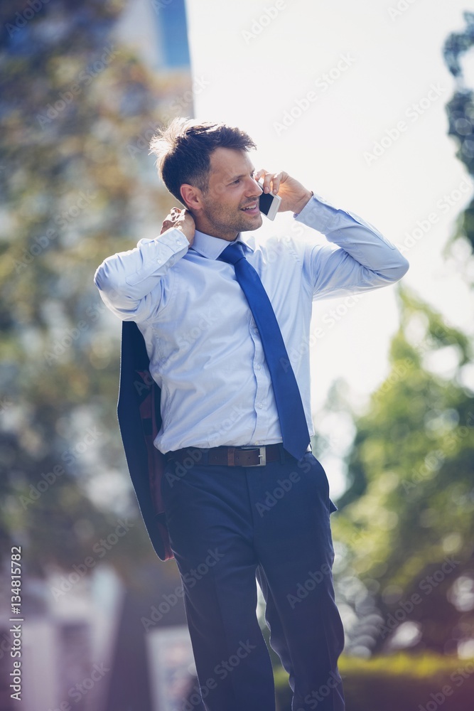 Low angle view of handsome businessman talking on mobile phone Low angle view of handsome businessman talking on mobile phone