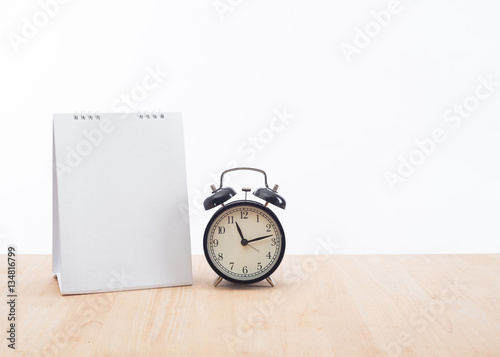 blank calendar planner with clock and wood desk office on white background.