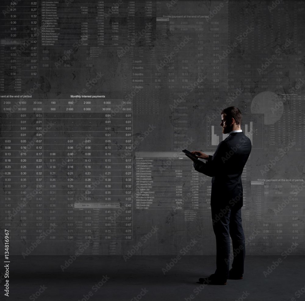 Businessman with a tablet with diagrams on the wall Businessman with a tablet with diagrams on the wall