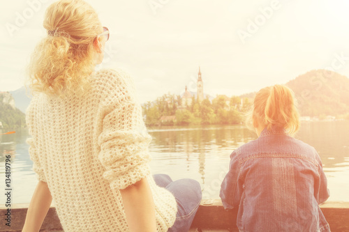 Mother and daughter enjoying the view on a lake.
