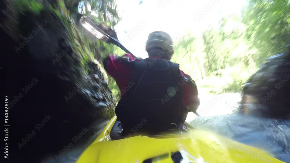 CLOSE UP: Adult extreme male kayaker running whitewater waterfall in wilderness