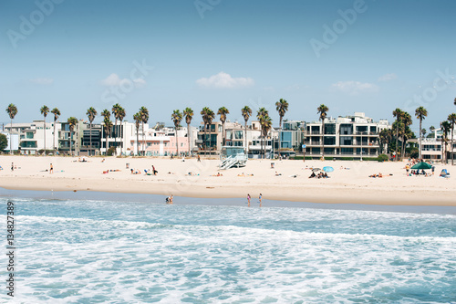 Pacific ocean coastline in Los Angeles USA. People walking at the beach. Rental buildings on Venice beach.