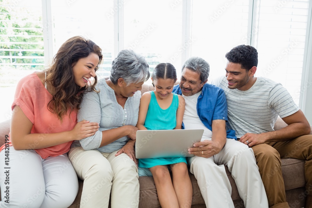 Happy multigenration family using laptop in living room Happy multigenration family using laptop in living room