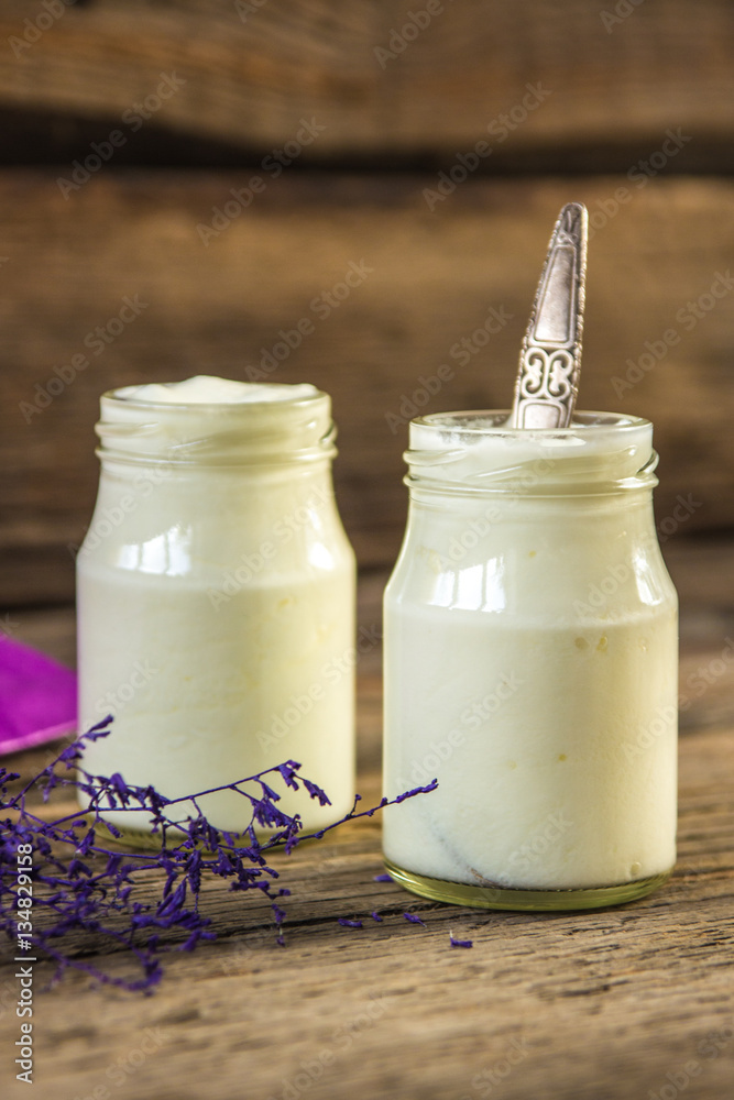 Yogurt in jar on the wooden table with purple dried plant Yogurt in jar on the wooden table with purple dried plant