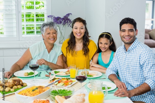 Happy multi generation family having meal on table at home