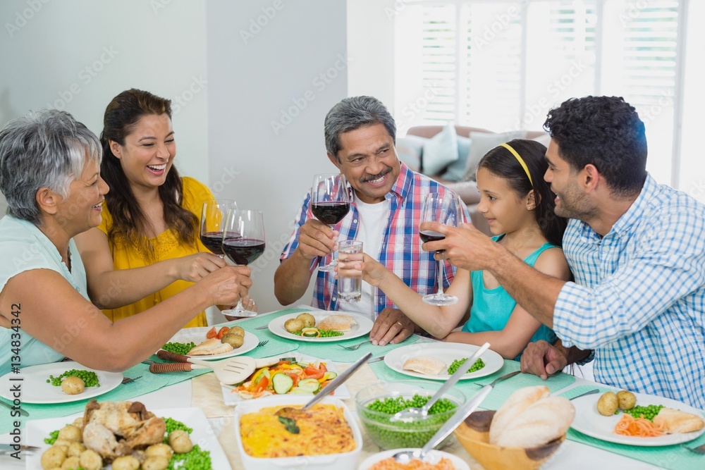 Happy family toasting a glasses of red wine 