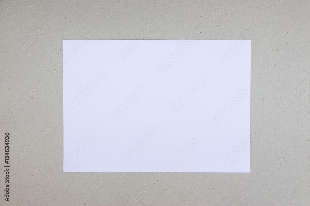 A simple composition of a white, blank a4 paper laid on a grungy brown paper background A simple composition of a white, blank a4 paper laid on a grungy brown paper background
