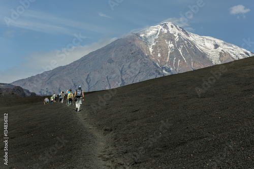 Fotografie Tourist pass cooled lava flow from a new crater on the slope of a volcano Tolbac