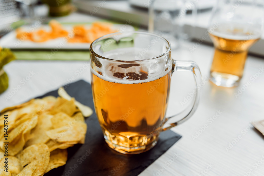 Beer and chips on the large white table Beer and chips on the large white table