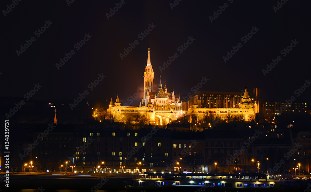 View on the illuminated Fisherman's Bastion on a winter night, surrounded by many lightened windows. Budapest.