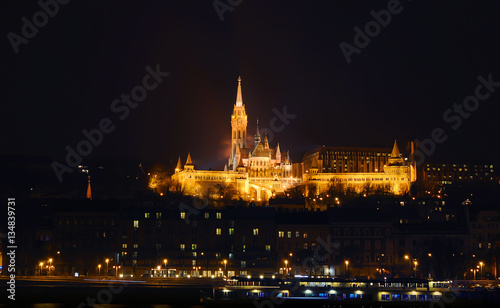View on the illuminated Fisherman's Bastion on a winter night, surrounded by many lightened windows. Budapest.