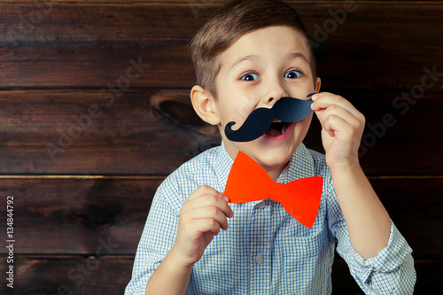 A kid with props for a photo booth. Surprised child with the req