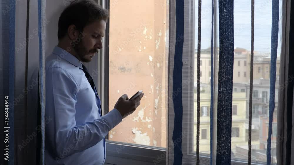 attractive business man at the window use the phone attractive business man at the window use the phone