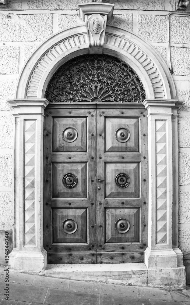 The entrance wooden door in an old Italian house (black and white). The entrance wooden door in an old Italian house (black and white).