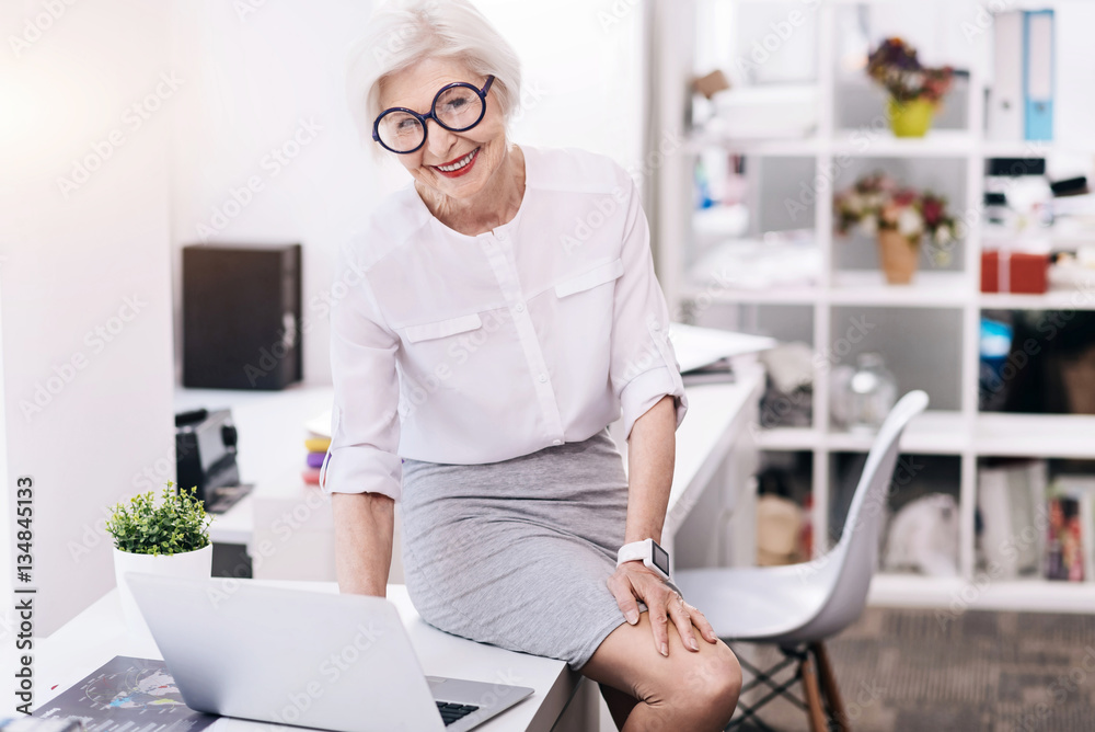 Amused funny business lady using the device in the office Amused funny business lady using the device in the office