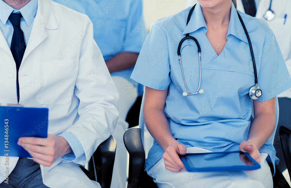 close up of happy doctors at seminar or hospital close up of happy doctors at seminar or hospital