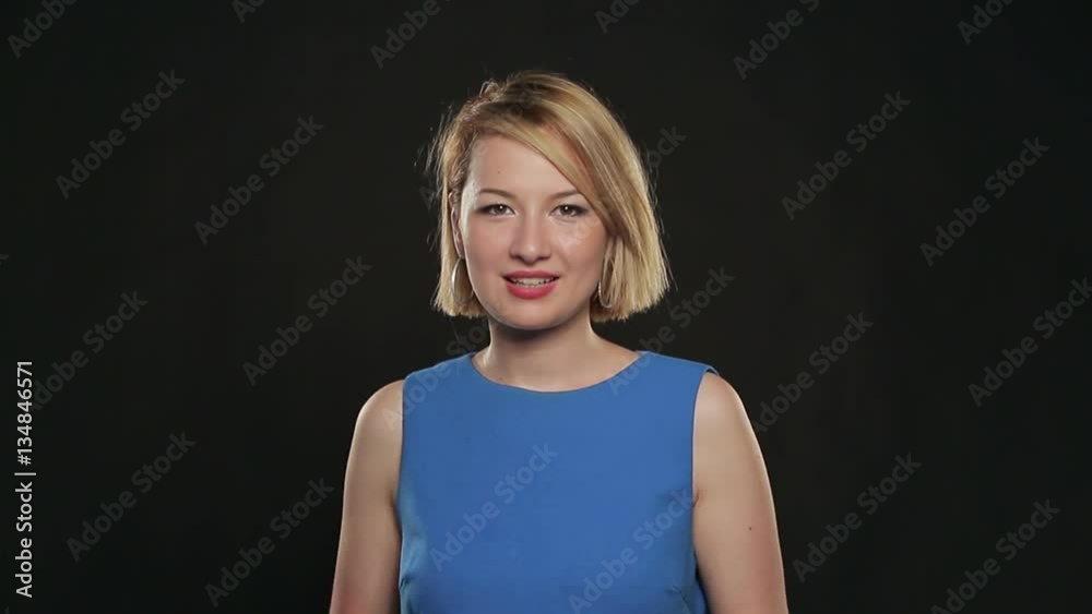 Mitis young woman in a blue dress posing on a black background. Positive emotions. Mitis young woman in a blue dress posing on a black background. Positive emotions.