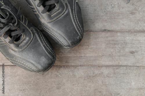 Black leather shoe on wooden board.