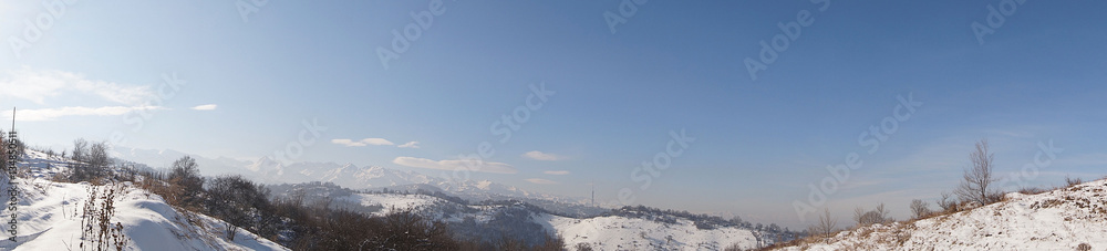 Winter landscape. View of the city and surrounding area. The mountains.
