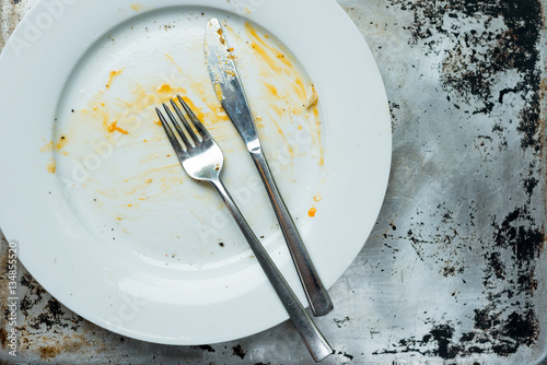 Empty Plate with Fork and Knife Left After Meal