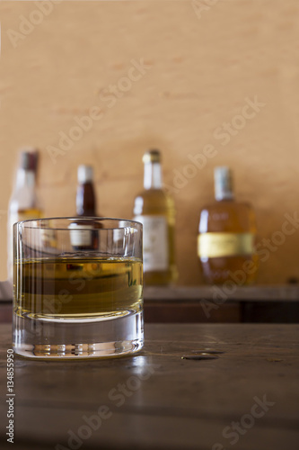 glass with whisky on wooden table