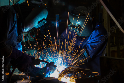 Team welder are welding in car factory photo