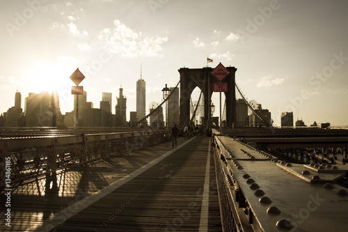 Walkway of Brooklyn bridge and buildings in Manhattan before sunset in sepia vintage style, New York © Spinel