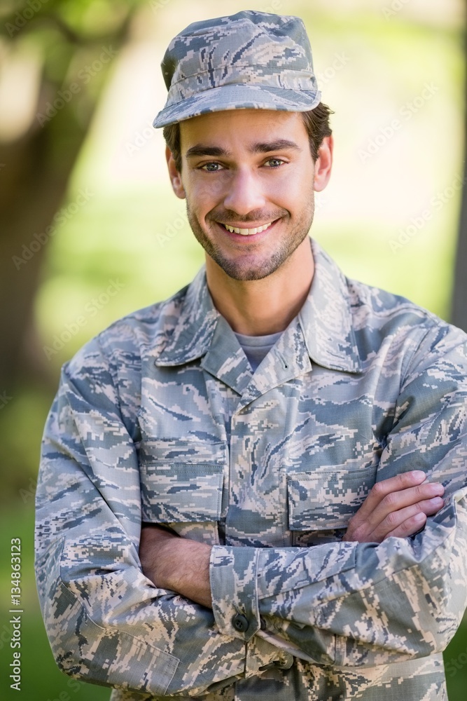 Portrait of soldier standing with arms crossed in park