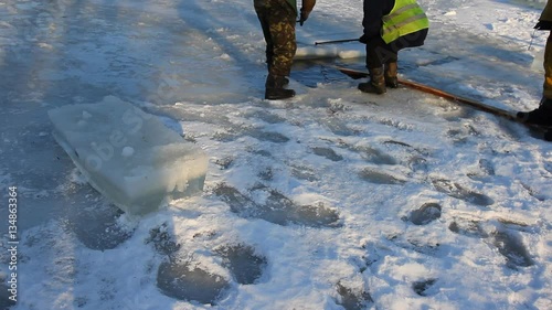 Blocks of ice are cut on an ice field and moved
