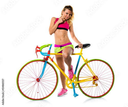 Fototapeta Naklejka Na Ścianę i Meble -  Beautiful blonde woman with colorful bike