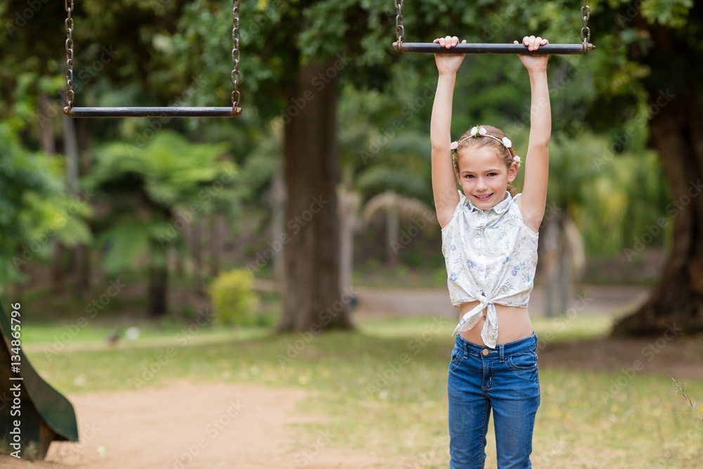 Girl hanging on a playing equipment in park Girl hanging on a playing equipment in park