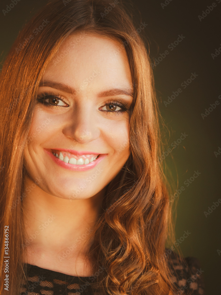 Fototapeta premium Happy woman curling her long brown hair