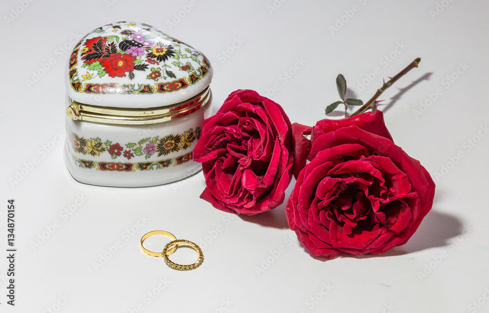 Fototapeta premium Romantic red roses with engagement rings and artistic jewelry case for Valentines Day isolated in white background.