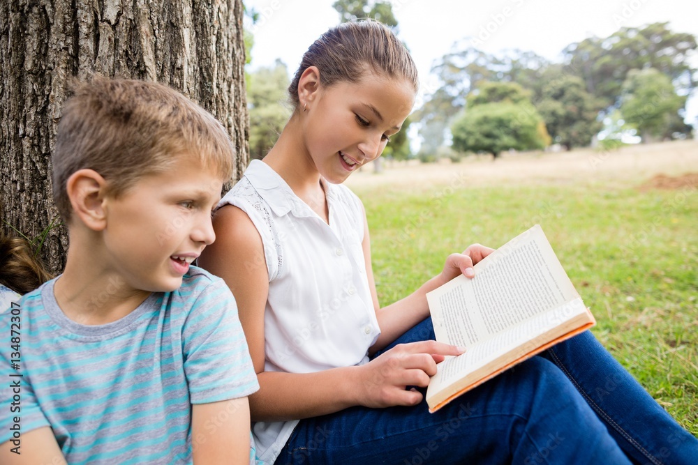Kids reading book in park Kids reading book in park