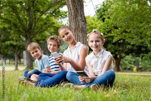 Kids using mobile phone in park