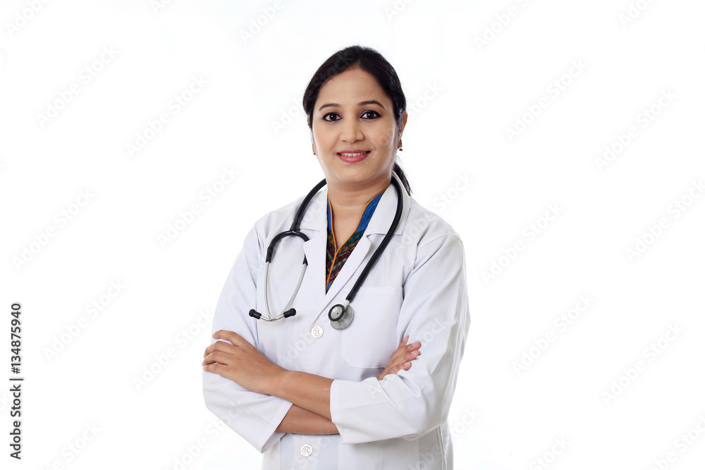 Smiling young doctor woman against white background