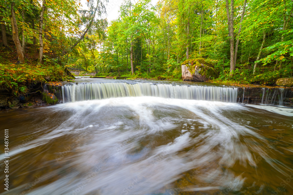 Small waterfall (cascade) on river with motion blur. Lahemaa national park, Estonia