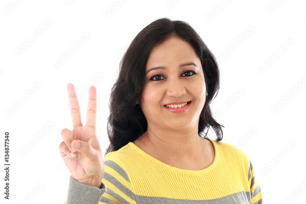 Young woman showing thumbsup gesture against white background Young woman showing thumbsup gesture against white background